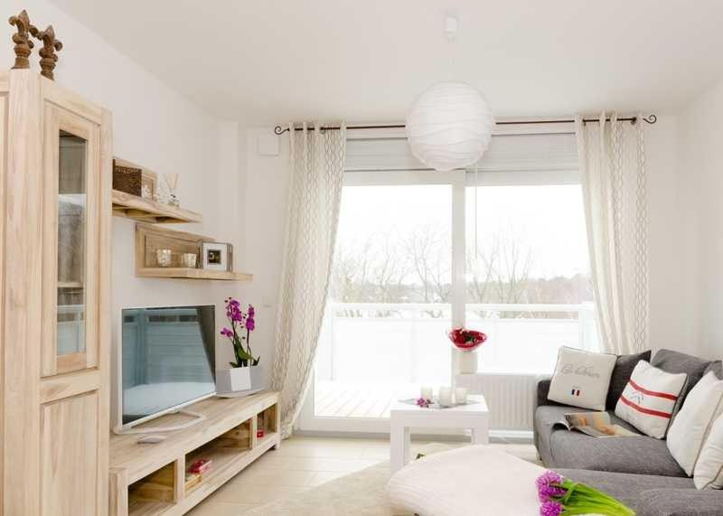 sala de estar con sofá y TV en SONNENDECK App Nr 19 max 4 Pers, en Dierhagen