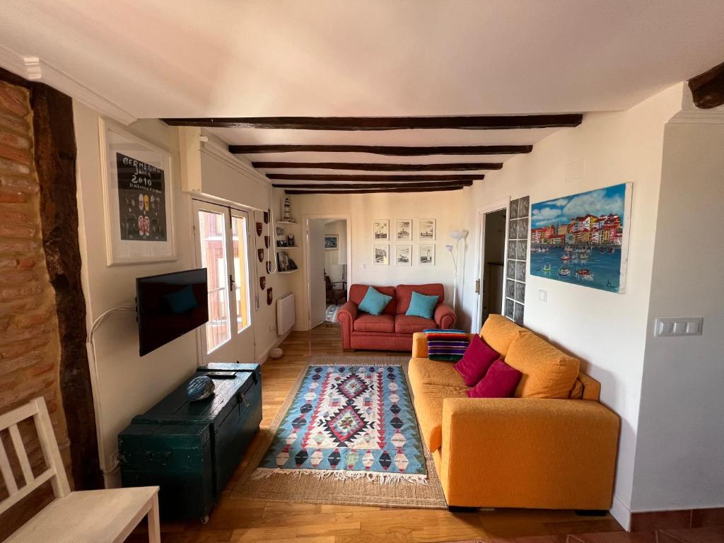 a living room with two couches and a tv at IZARO EYE Bermeo in Bermeo