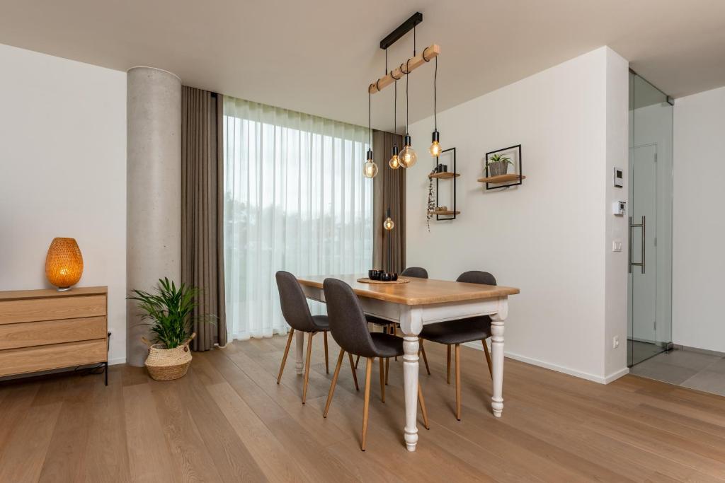 a dining room with a wooden table and chairs at Duinenrij 197 in Bredene