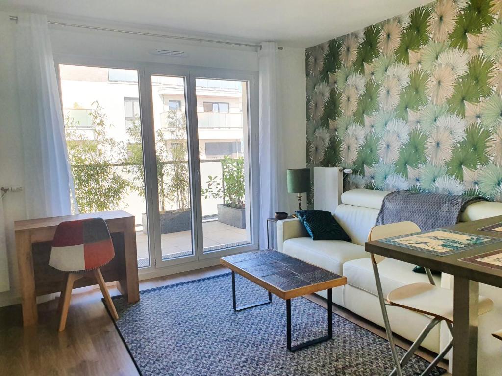 un soggiorno con divano e tavolo di EXIGEHOME-Bel appartement de standing-30 minutes de Paris a Vélizy-Villacoublay