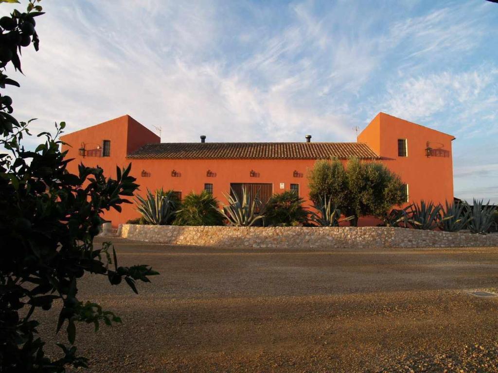 a large orange house with a road in front of it at Casas Rurales Venta Seca complejo Rural para 24-28 plazass in Mazarrón