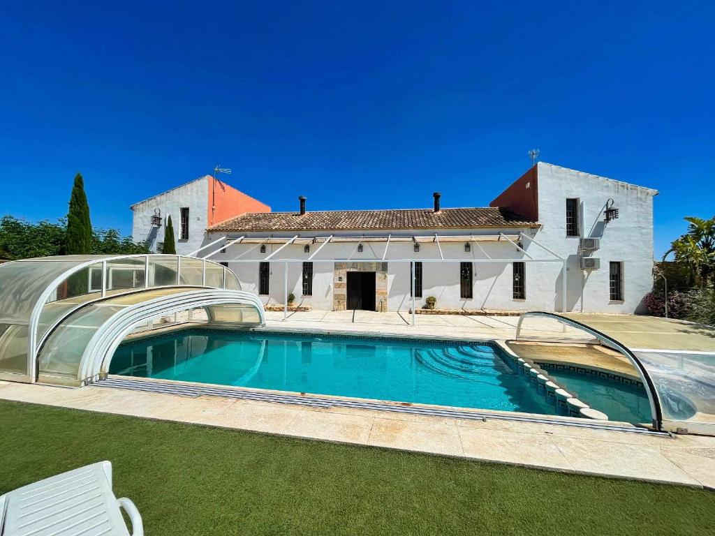 una piscina frente a una casa en Casas Rurales Venta Seca hasta 24 plazas, en El Romero