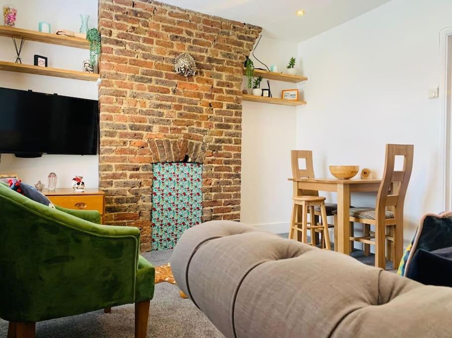 a living room with a brick fireplace and a couch at Funky 2 Bedroom Apartment In Town Centre in Hastings