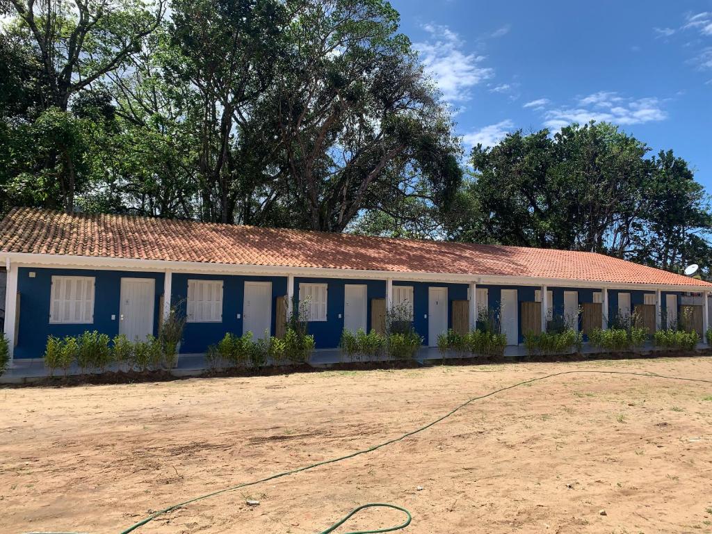 um edifício azul e branco com um telhado vermelho em Suítes Maresias em São Sebastião