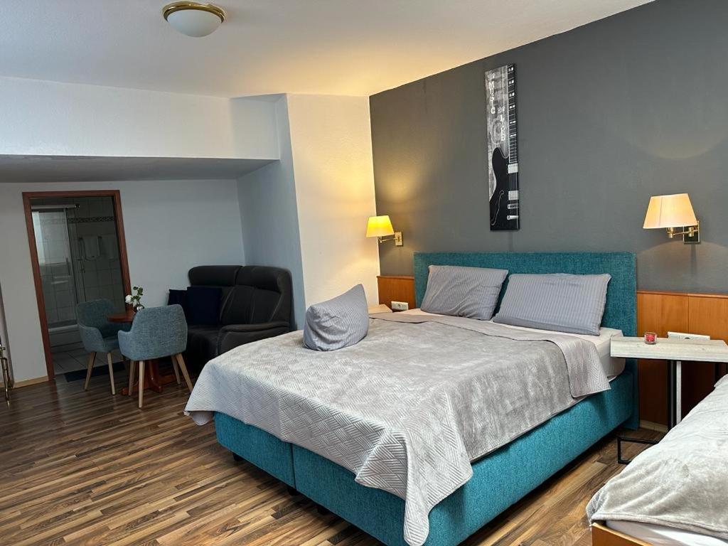 a bedroom with a large bed with a blue bed frame at Hotel Oberledinger Hof in Leer