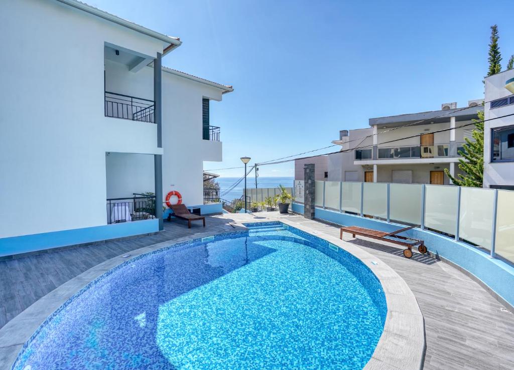 een zwembad in de achtertuin van een appartement met een gebouw bij Vila Camacho Guest House in Funchal