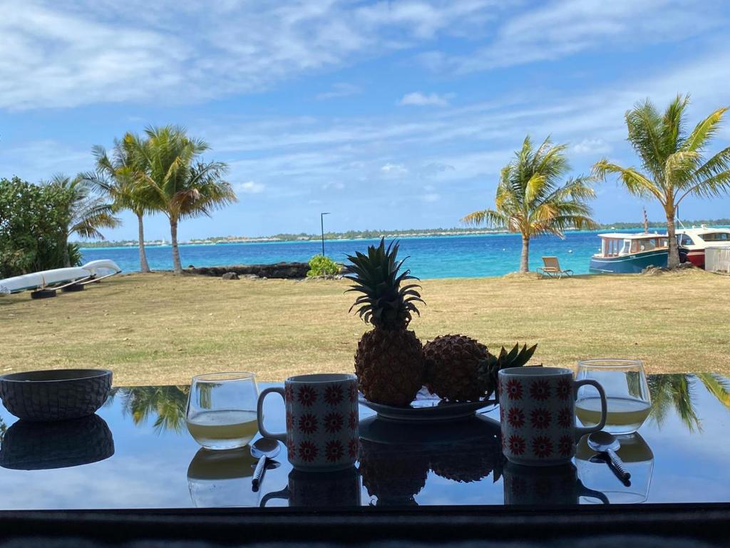 a table with two pineapples on it with a view of the ocean at Haamaire in Bora Bora