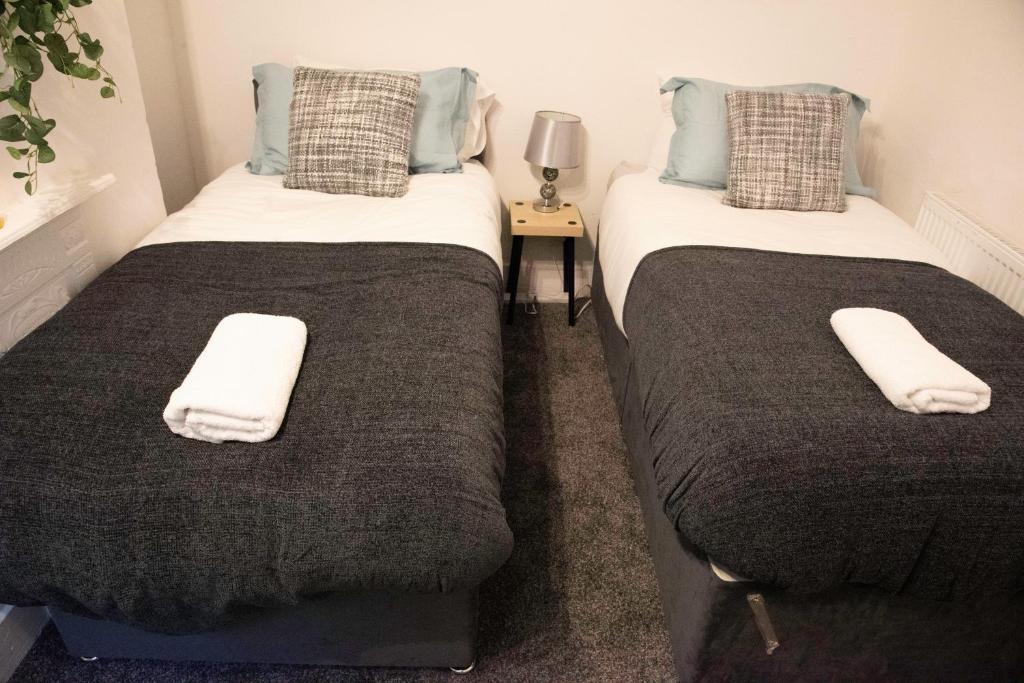 two beds sitting next to each other in a room at Coral Place in Luton