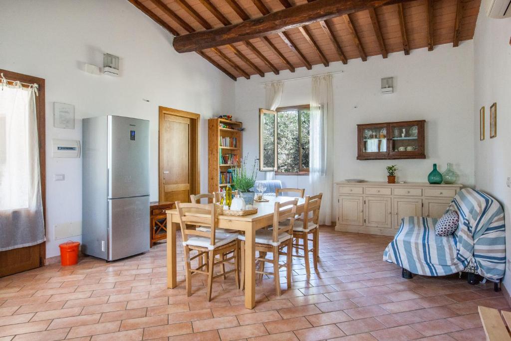 uma cozinha com uma mesa e cadeiras e um frigorífico em Agriturismo Fontetrilla em Orbetello