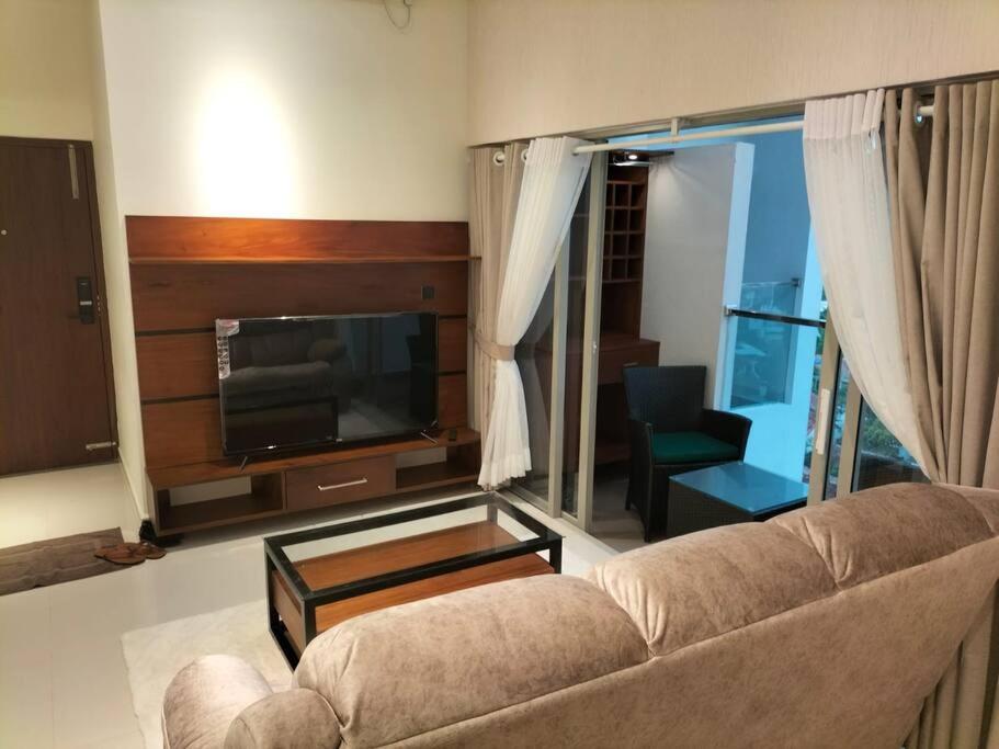 a living room with a couch and a flat screen tv at Apartment with Pool & Gym in Colombo
