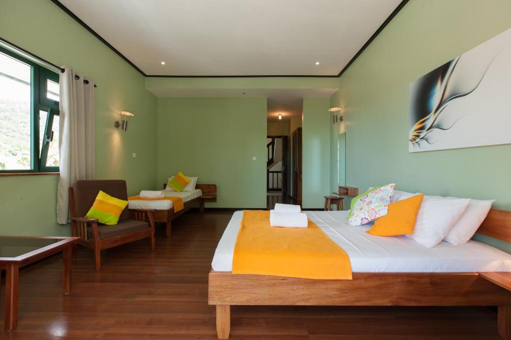 a bedroom with a bed and a living room at La Kaz Safran in La Digue