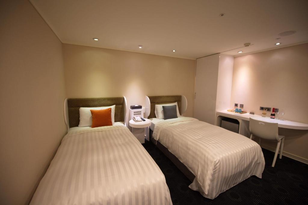 a hotel room with two beds and a sink at Ximen Airline Hotel in Taipei