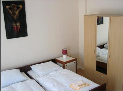 ein Schlafzimmer mit einem Bett und einem Spiegel mit einem Kreuz an der Wand in der Unterkunft Kölner Pension in Köln