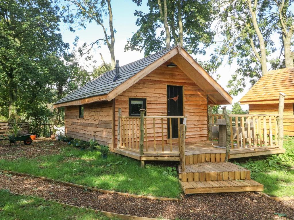 eine Blockhütte mit einer Veranda und einer Terrasse in der Unterkunft Pheasant in Carthorpe
