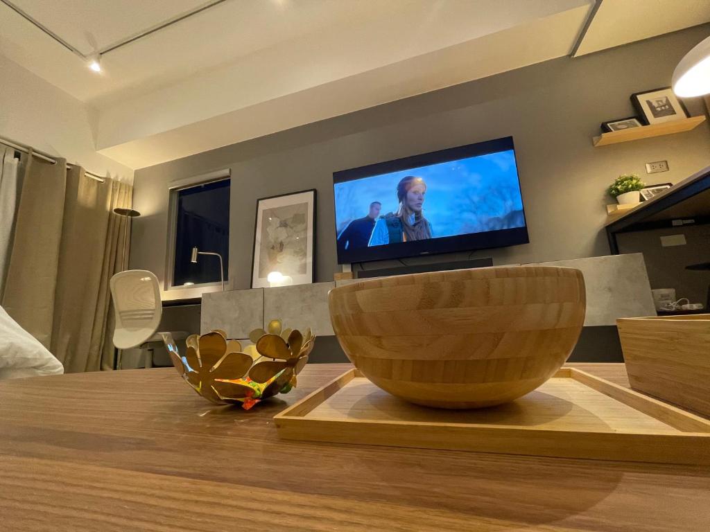 a living room with a television and a wooden bowl on a table at 8 Sun Staycation in Manila