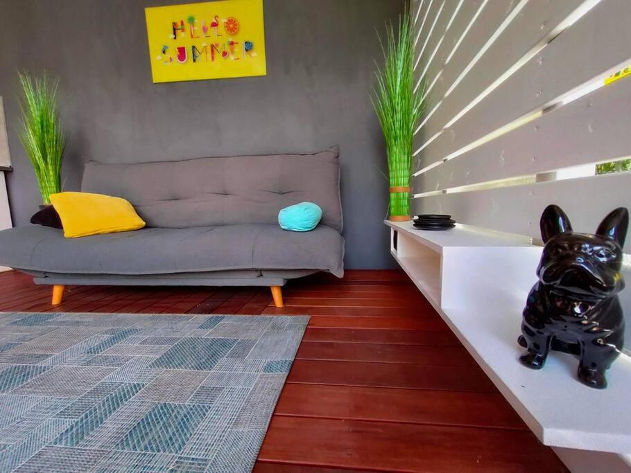 ein Wohnzimmer mit einem Sofa und einer Hundestatue in der Unterkunft Bungalow les Songes in L’Étang-Salé