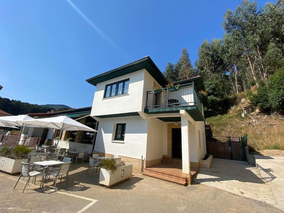 Dieses weiße Haus verfügt über einen Balkon sowie einen Tisch und Stühle. in der Unterkunft Casa en Montealegre reformada y acogedora (wifi) in Sámano
