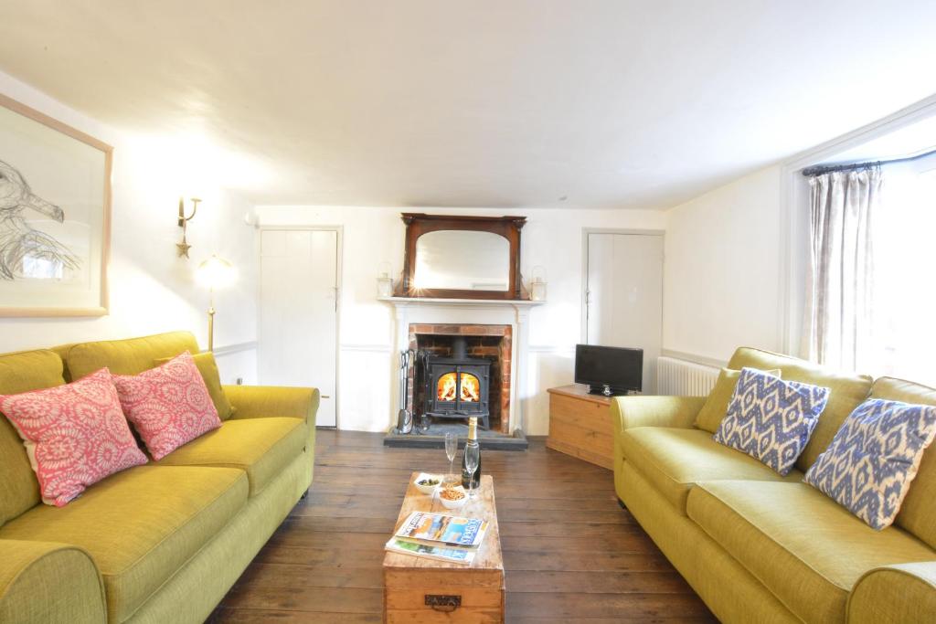 a living room with two couches and a fireplace at Tiger Villa, Aldeburgh in Aldeburgh