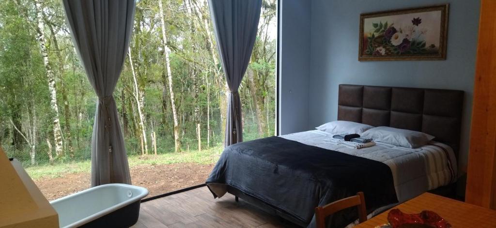sypialnia z łóżkiem i dużym oknem w obiekcie Casa Kafka - Bio Cult w mieście Campo Alegre