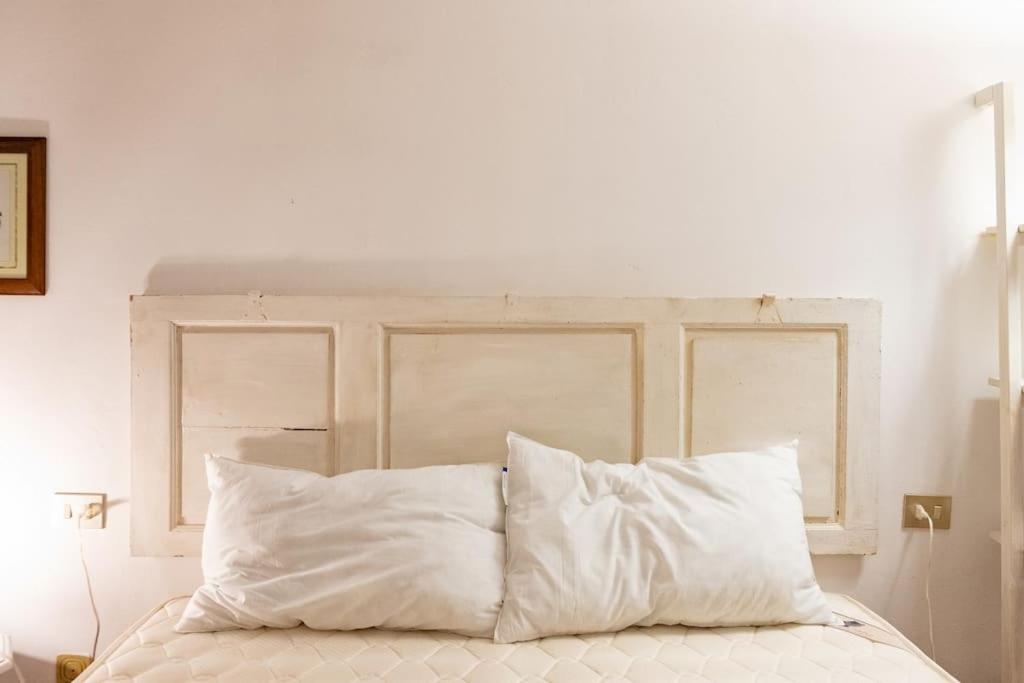 łóżko z białą pościelą i poduszkami w sypialni w obiekcie Classic Florentine Flat Near Piazza Santa Croce we Florencji