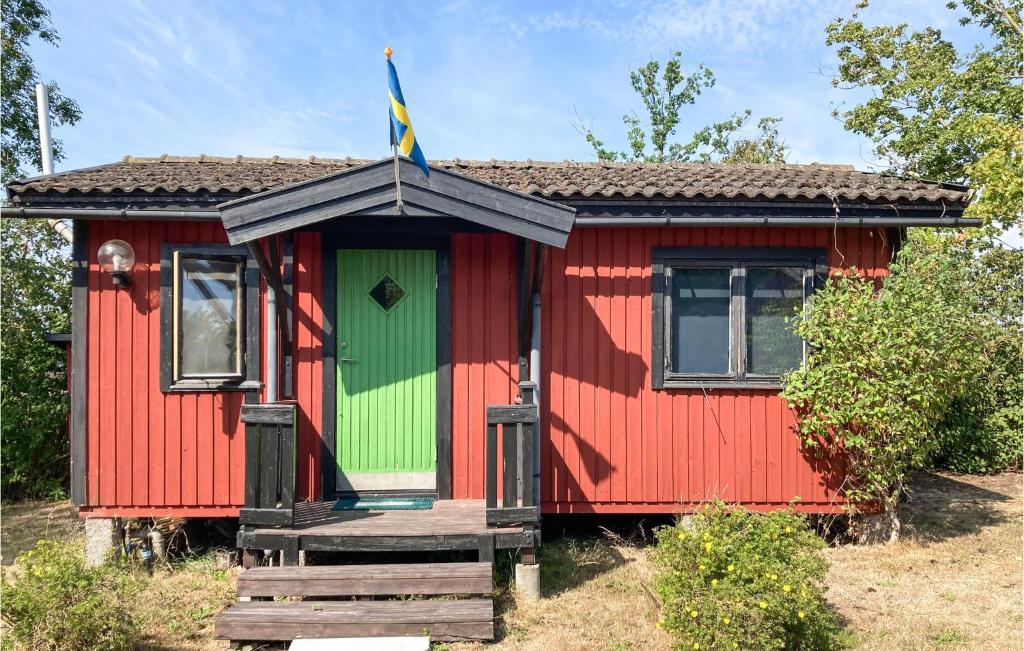 uma casa vermelha e verde com uma bandeira no topo em Awesome Home In Lttorp With Kitchen em Löttorp