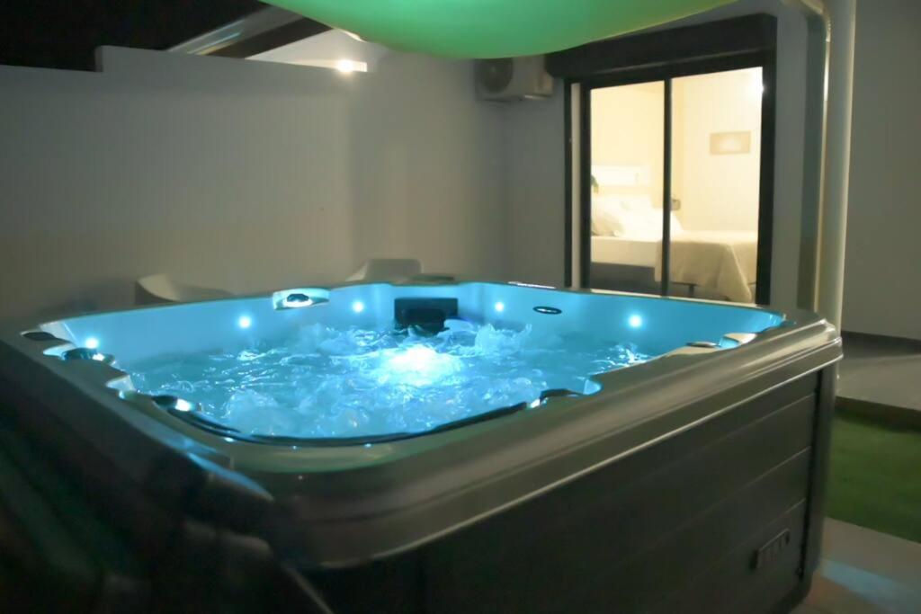 a blue hot tub in a room with a mirror at Lodge Palmeraie & son Jacuzzi exclusif in Matoury