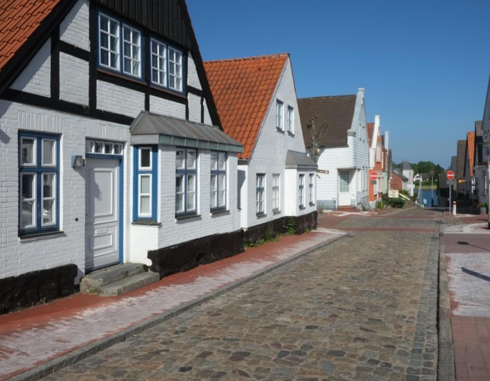 a cobblestone street lined with white and black houses at Wohnen am Dehnthof Haus 2 in Kappeln