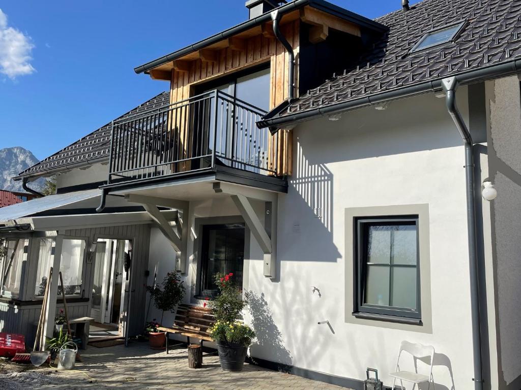 uma casa branca com uma varanda e um banco em Appartements BERGTRAUM em Gröbming
