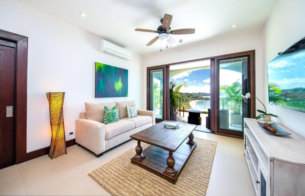 sala de estar con sofá y mesa en 360 Splendor 201-Ocean View Condo-Breakfast Included! en Playa Flamingo