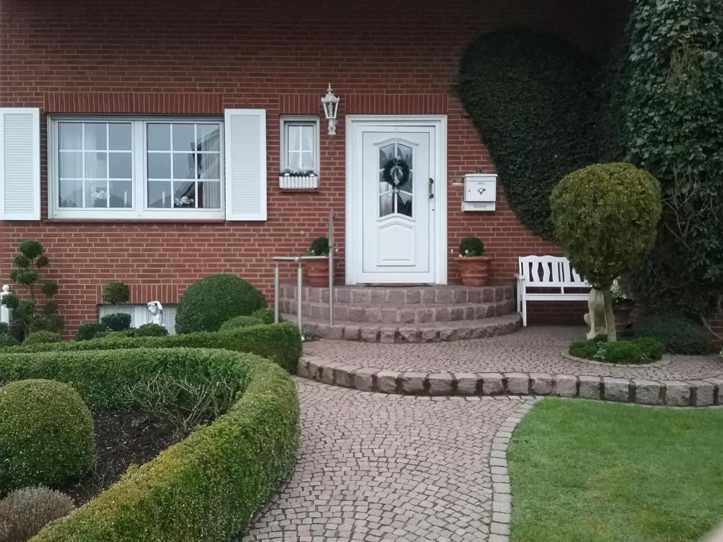 a brick house with a white door and a bench at Urlaubs Oase in Telgte