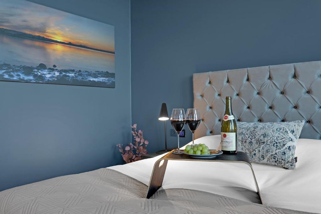 ein Bett mit einem Tisch, einer Flasche Wein und Gläsern in der Unterkunft Alva Hotel in Reykjavík