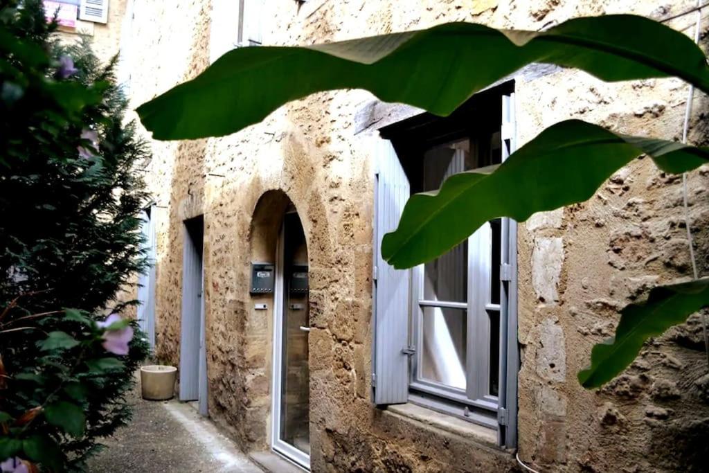 - une entrée pour un bâtiment en pierre avec une fenêtre dans l'établissement LE MOULIN A VENT maison plein centre de SARLAT, à Sarlat-la-Canéda