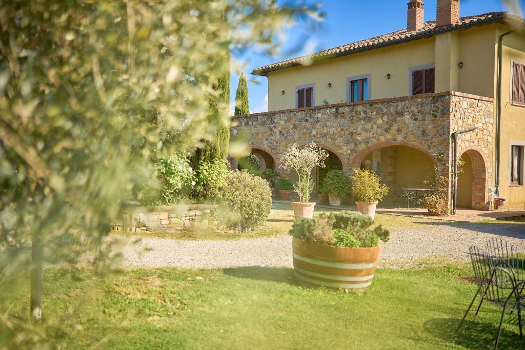 a building with a yard with potted plants in front of it at Il Poggio in Celle sul Rigo