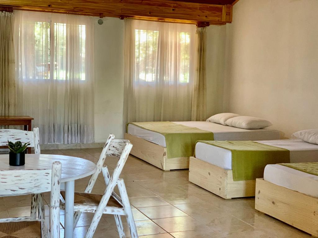 een kamer met 2 bedden en een tafel en stoelen bij El RECREO 4 in Garupá