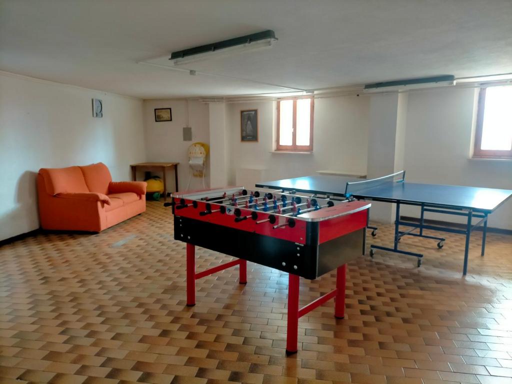 a room with a ping pong table and a couch at Faggio Rosso in Filettino