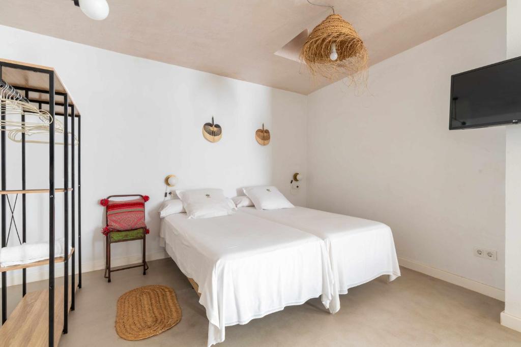 a white bedroom with a bed and a tv at Erizo 3 loft diafáno en el Centro Histórico in Tarifa