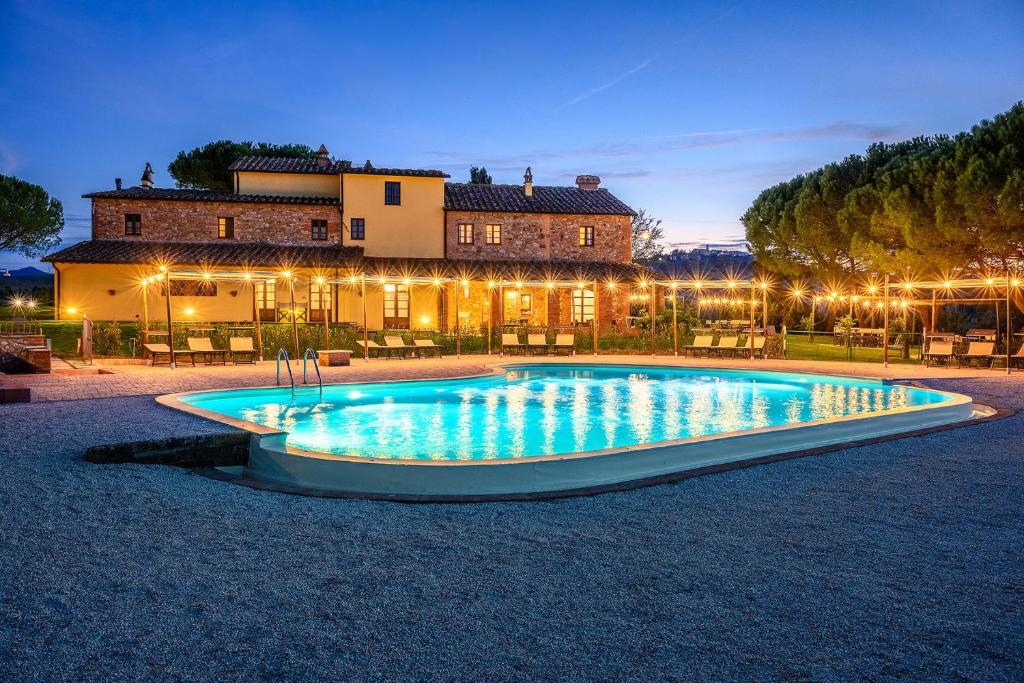 a large swimming pool in front of a house at Casa d'Era Country Holiday Houses in Lajatico