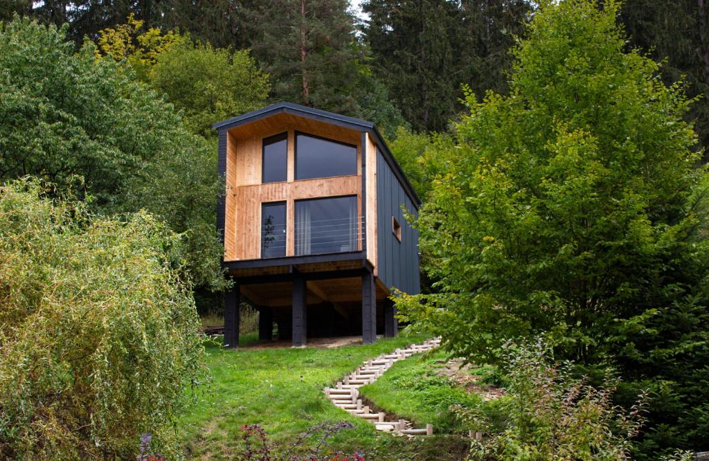 ein Haus auf einem Hügel mit Bäumen im Hintergrund in der Unterkunft Panorama / TinyHouse in Podbrezová