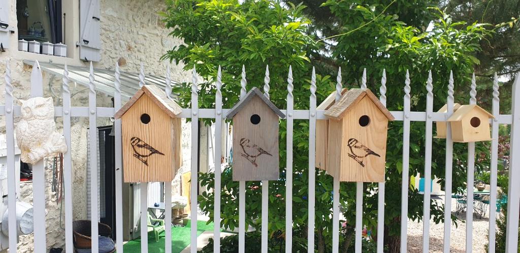 a fence with wooden bird houses on it at Le(s) Nichoir(s) Pusignieu in Creys-et-Pusigneu