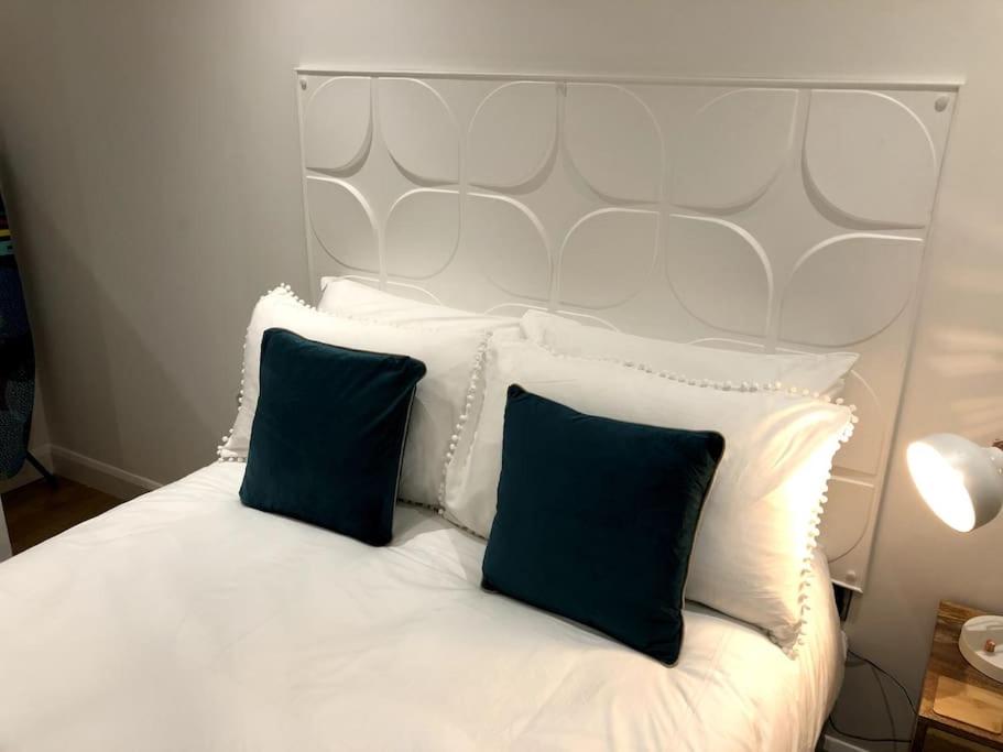 uma cama branca com duas almofadas azuis em Sitwell coastal apartment with free parking em Scarborough
