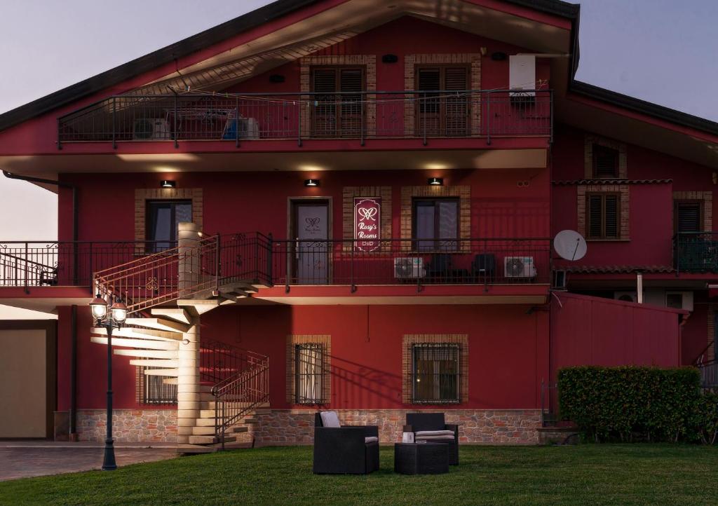 a red building with two balconies on it at Rosy's Rooms in Patrica