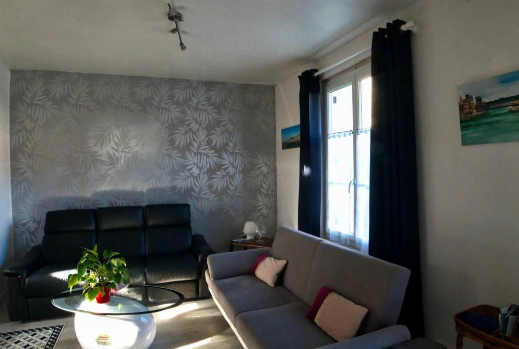een woonkamer met een bank en een tafel bij Chez Pia in Dieppe