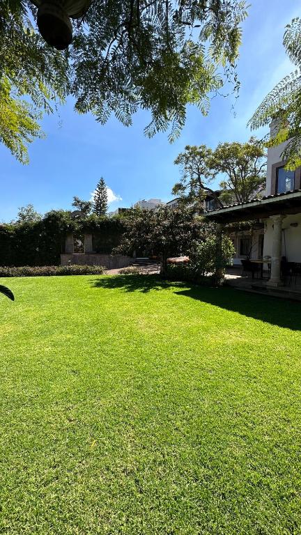 a large grassy yard with a house in the background at Maja Hotel Boutique in Morelia