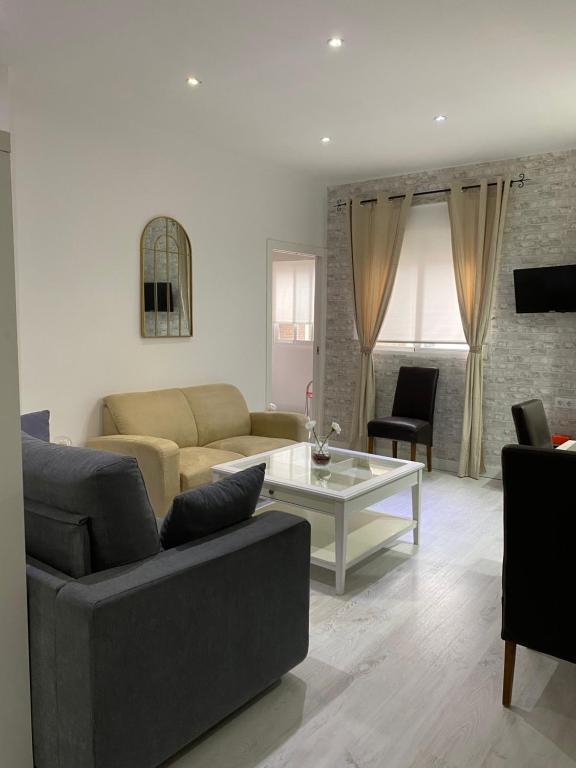 sala de estar con sofá y mesa en PRECIOSO Y ACOGEDOR APARTAMENTO EN PLENO CENTRO DE GRANADA, en Granada