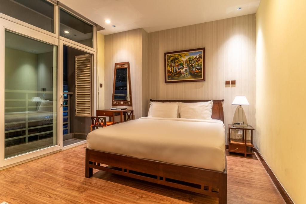 a bedroom with a bed and a large window at The Rixx Indochine Apartment with Balcony and Rooftop Pool in Ho Chi Minh City