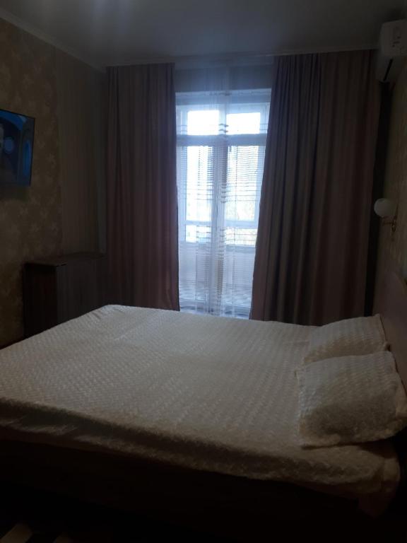 a bedroom with a white bed and a window at comfortable apartment in Chişinău
