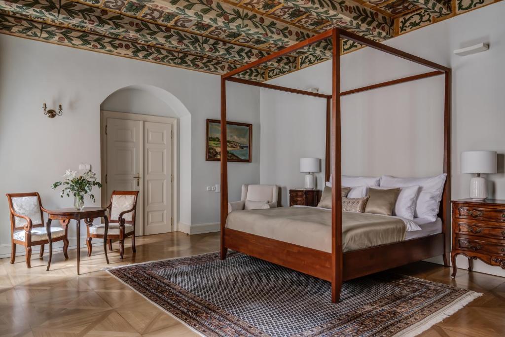 ein Schlafzimmer mit einem Himmelbett und einem Tisch in der Unterkunft Hotel Nerudova 211 in Prag