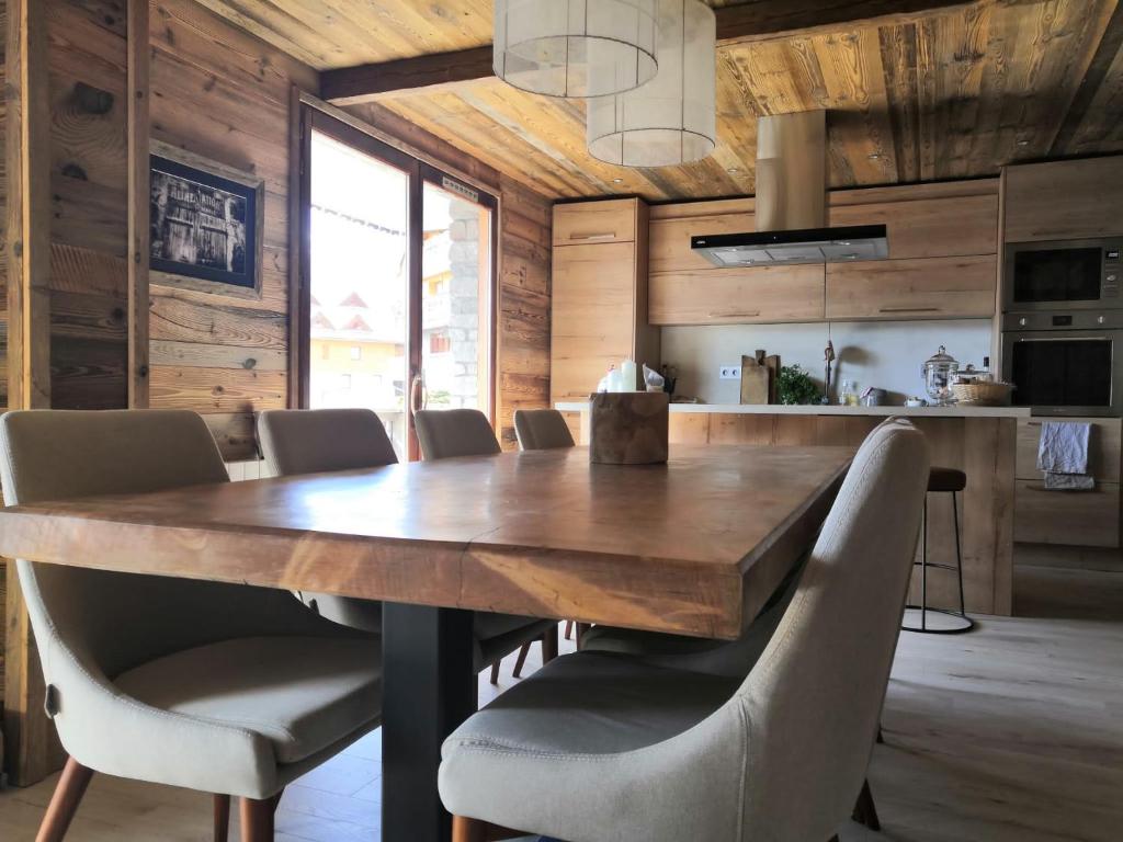 une salle à manger avec une grande table et des chaises en bois dans l'établissement Le Lodge de Molanes - Pra Loup 1500, à Pra-Loup