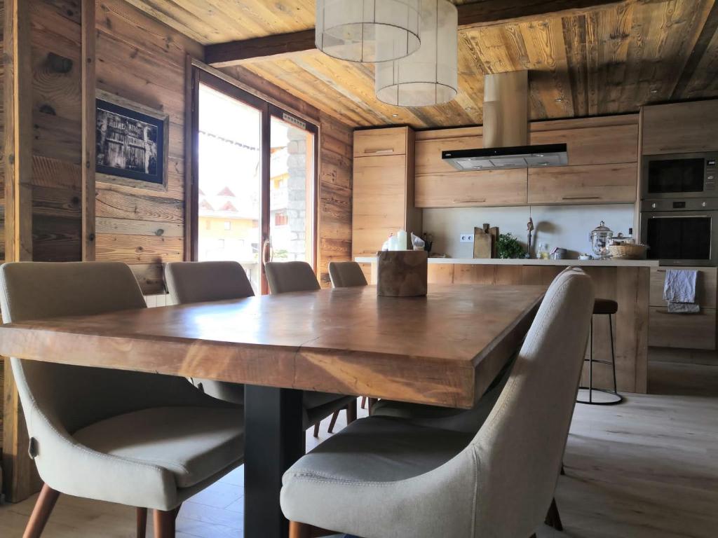 Un comedor con una gran mesa y sillas de madera. en Le Lodge de Molanes - Pra Loup 1500, en Pra-Loup
