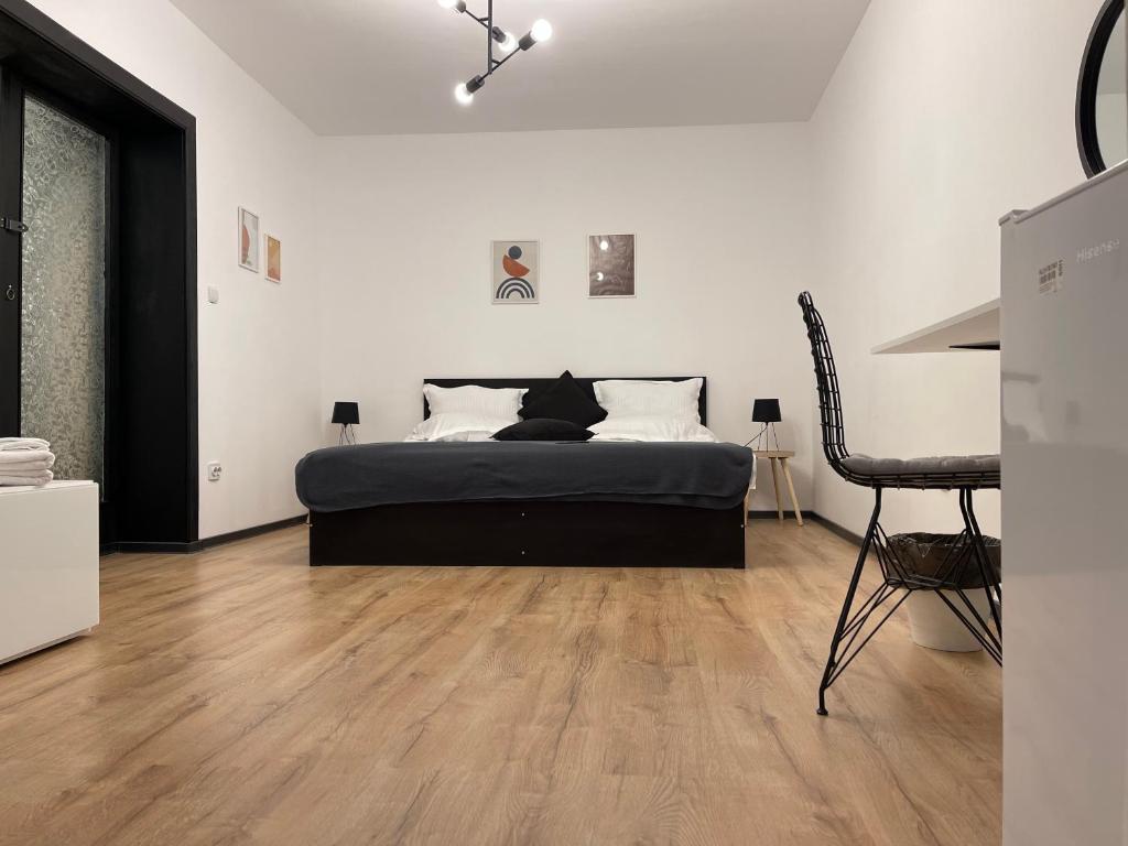 Cama negra en habitación blanca con suelo de madera en Nordic Villa en Brasov
